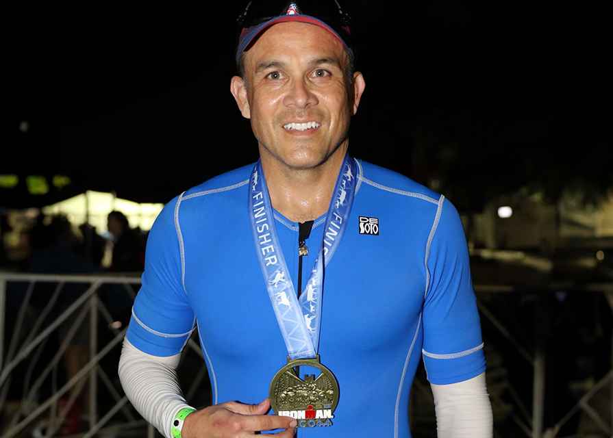 Man wearing a medal poses after finishing a race